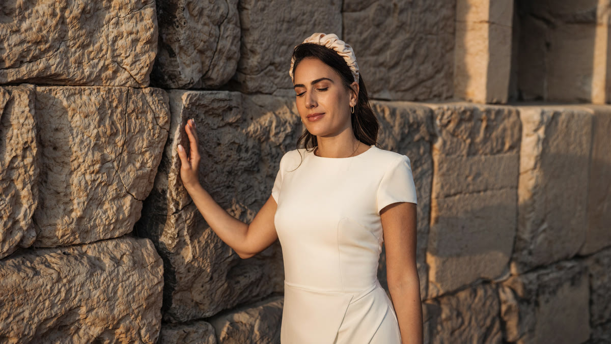 אישה בתפילה אישית ליד הכותל המערבי בשעת זהב